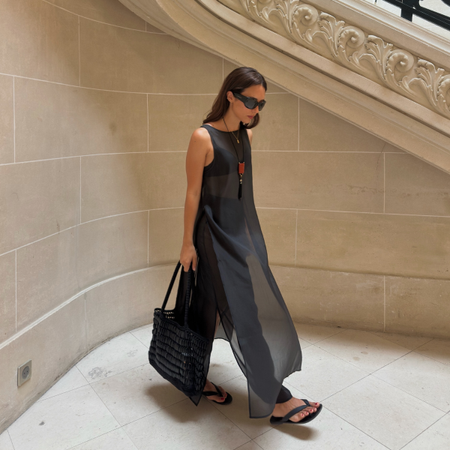 Debora in a sheer top, trousers and flip-flops