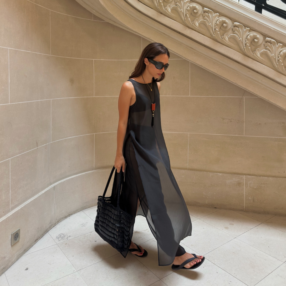 Debora in a sheer top, trousers and flip-flops
