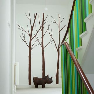 hallway with white wall and stairs with painted balusters