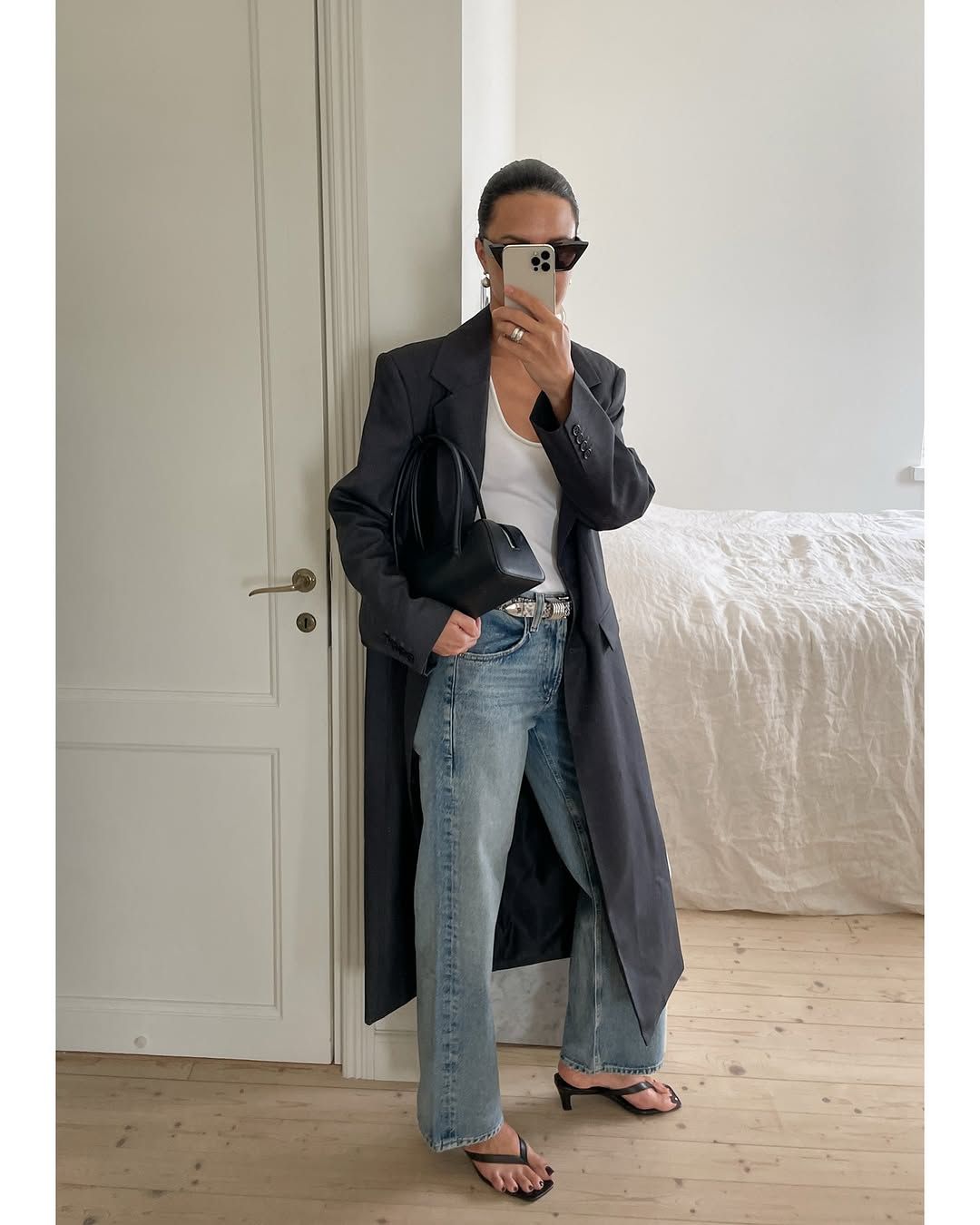 Woman wearing dirty denim jeans, a fall 2025 trend.