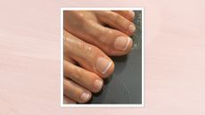 A close-up of a person's feet, which feature a neutral and white French pedicure created by nail artist Milly Mason (@millymason_)/ pictured against a grey floor and in a pink template