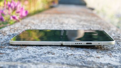 Google Pixel 10 Pro Fold in Jade green outside at a flower garden on a sunny day