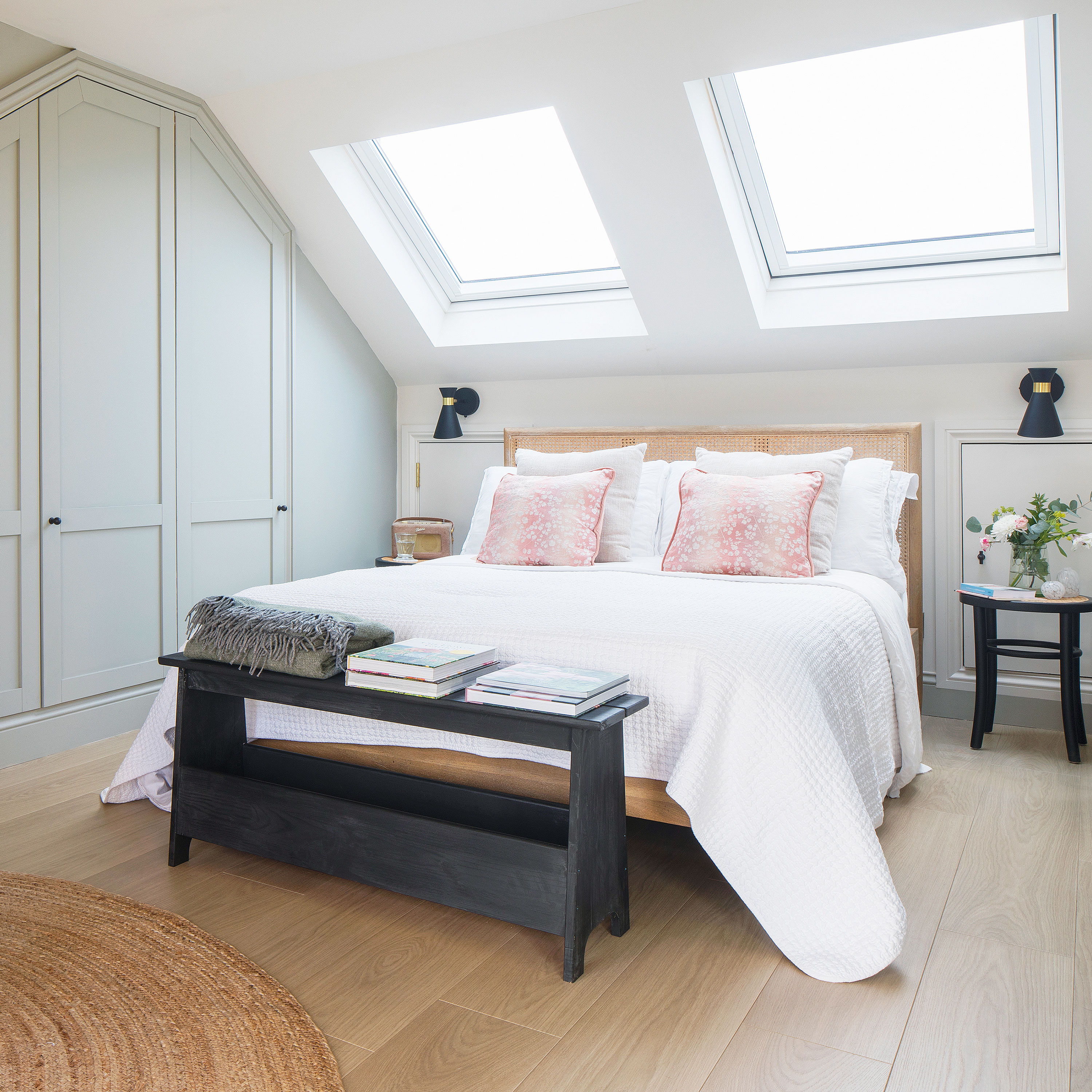 White bedroom with built in wardrobes and two wall mounted bedside lamps