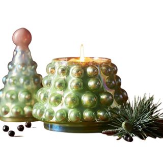 A green Christmas candle jar in the shape of a Christmas tree