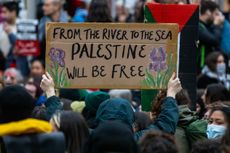 A pro-Palestinian activist holds up a sign reading 'From The River To The Sea Palestine Will Be Free'