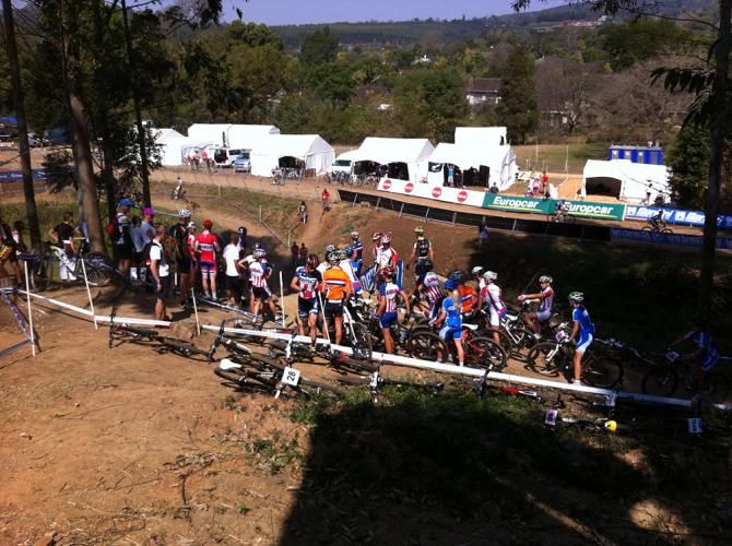 Riders queue up on the cross country course at a rock garden to watch each other's lines