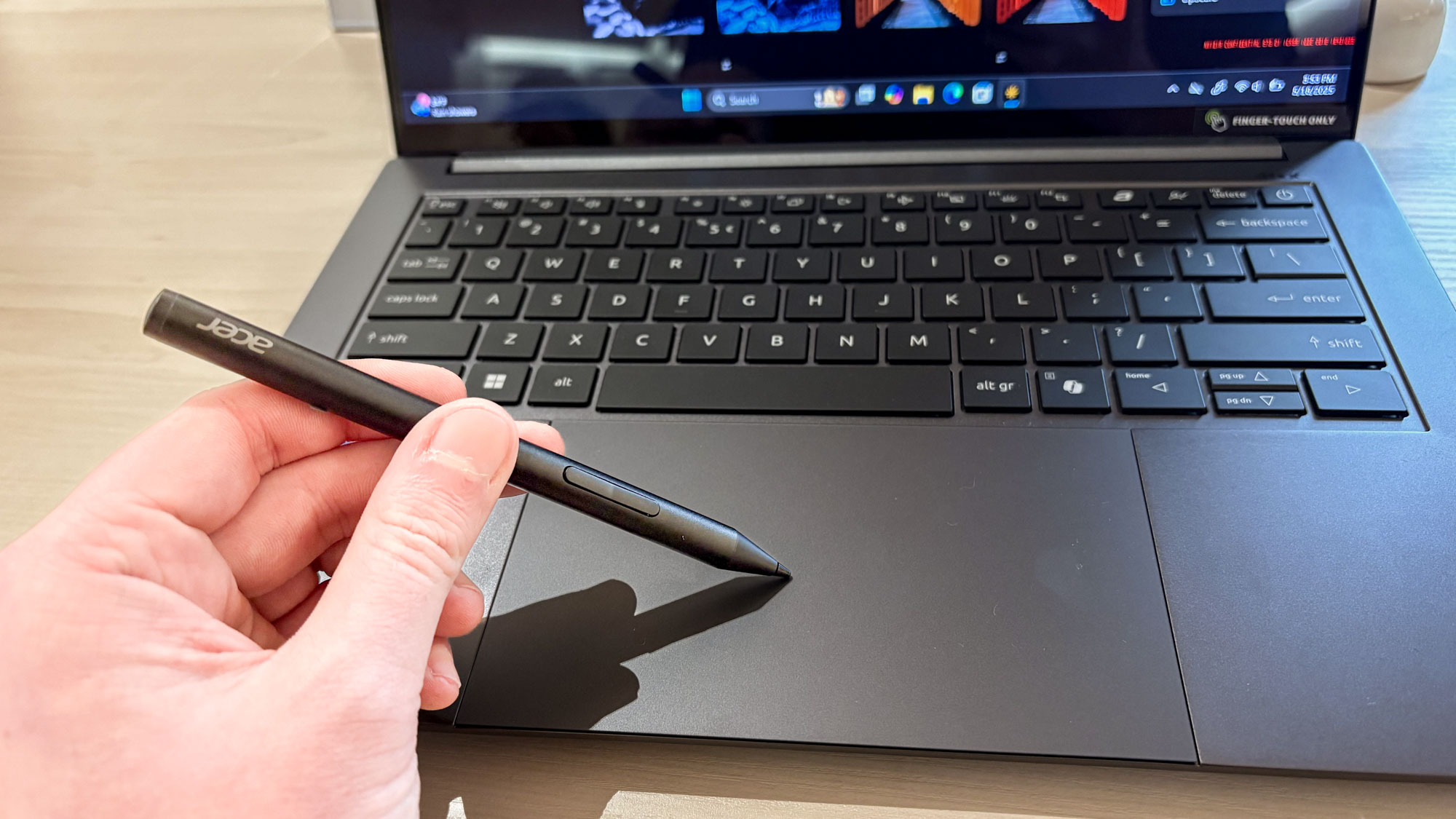 Hand holding Acer Stylus pen on Acer Swift X 14 touchpad