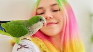 Teenage girl with bird sitting on her shoulder