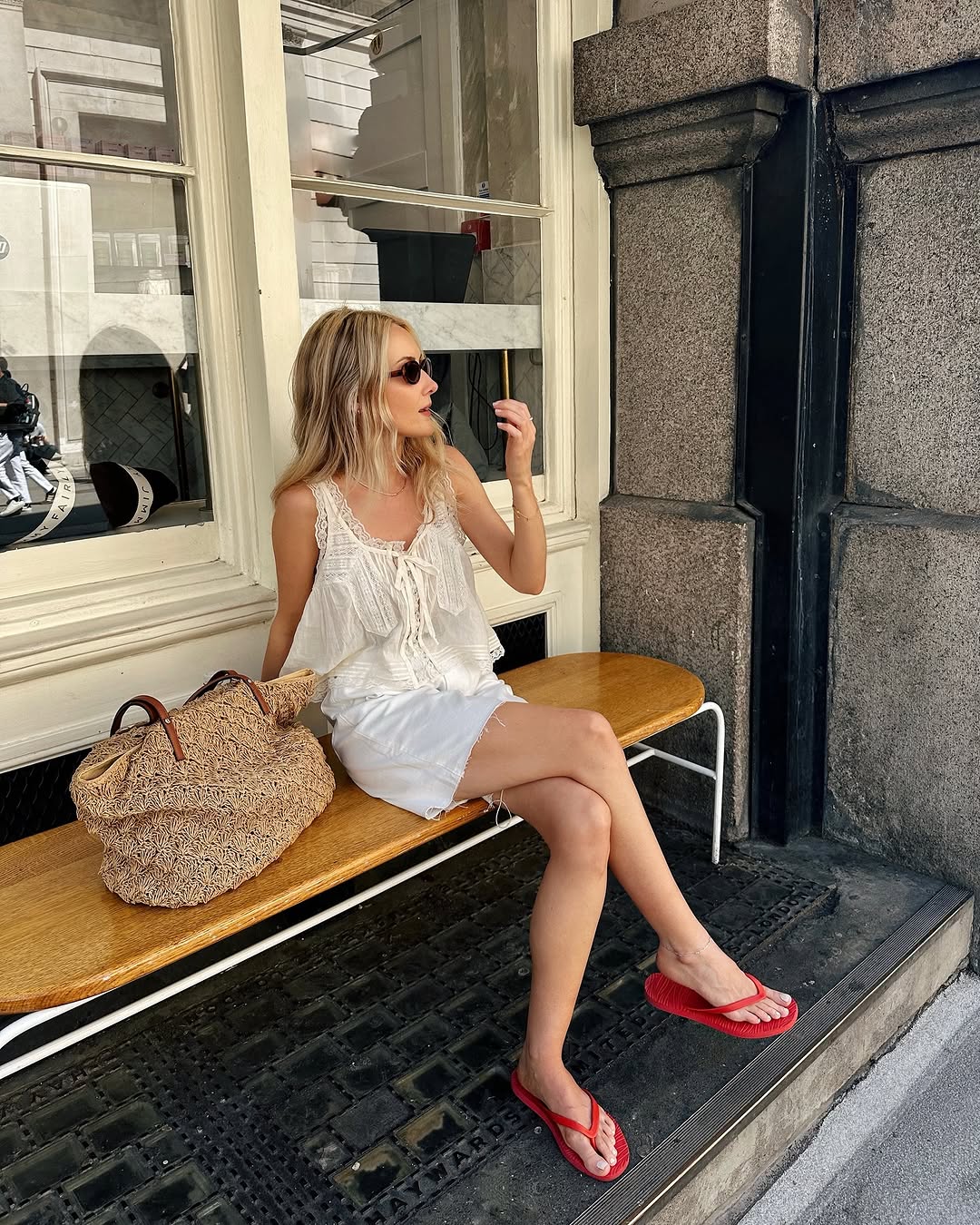 woman wearing white denim cut off shorts and red flip flops