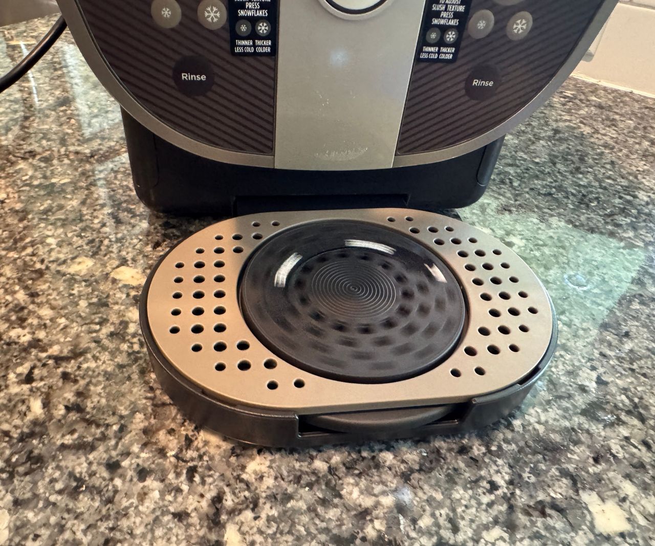 A close up view of the rotating drip tray on the ninja slushi twist