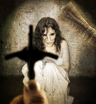 A scared girl with a cross as if getting an exorcism,