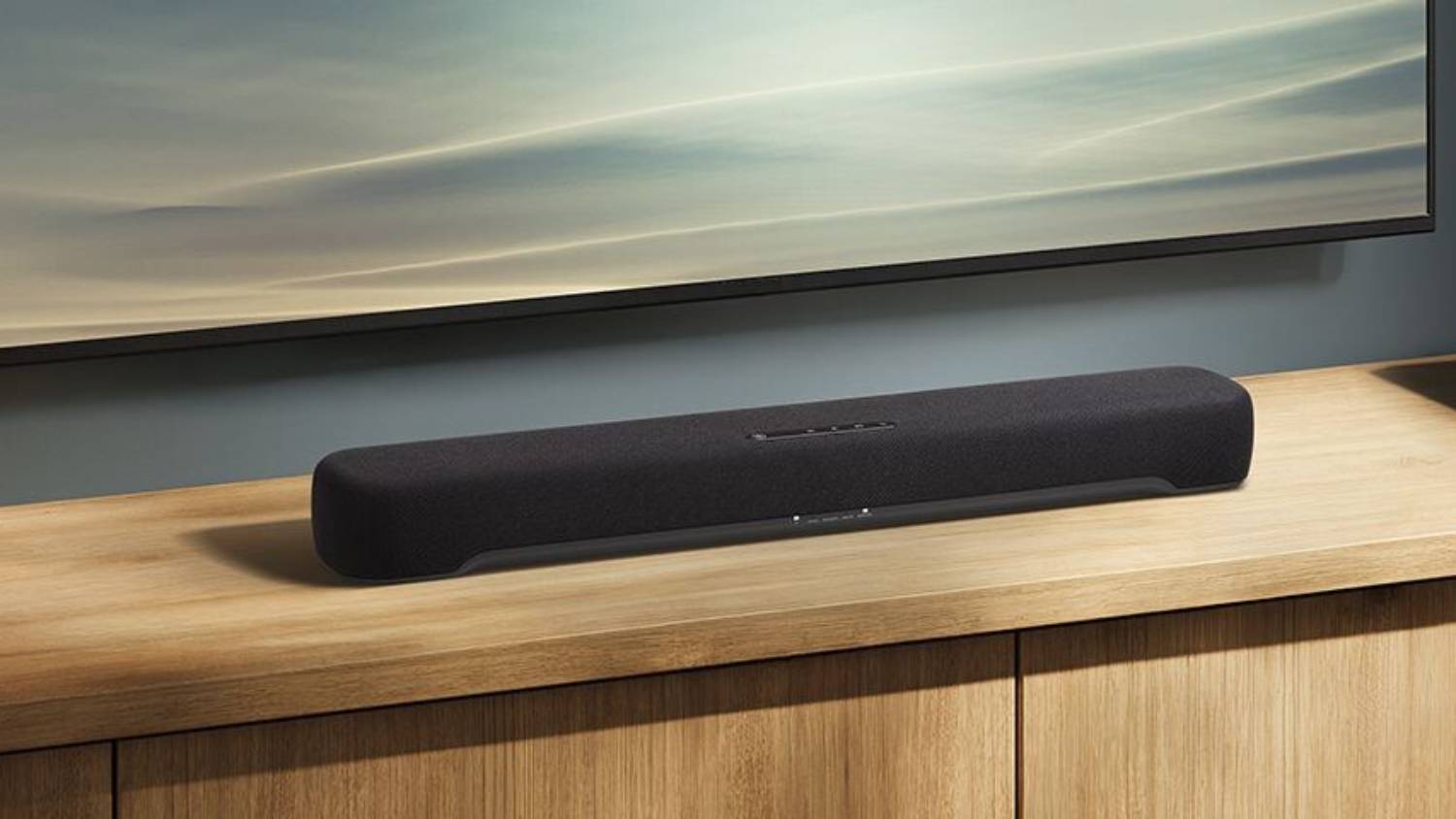 The Yamaha B200A on a wooden shelf under a TV.