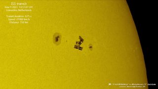 the international space station crosses the sun's face between two big sunspot groups