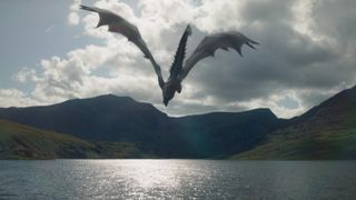 A dragon flies over a body of water in House of the Dragon season 2