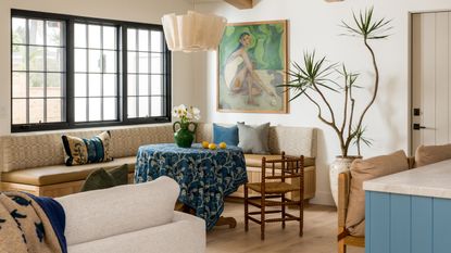 banquette seating in a bright white room with a blue tablecloth over the dining table