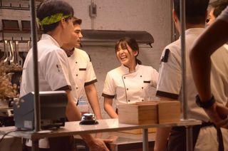 a group of chefs laugh in a kitchen in the tv show oh my ghost