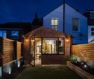 Brick extension by Woodrow Architects with outdoor lighting