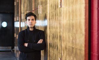 Matias Umpierres poising next to a gold wall