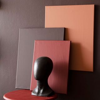 chocklate and orange paint with black statue on stool