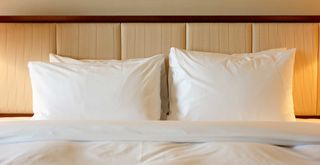 pillows on a hotel-style bed to support an article to answer how often you should replace pillows