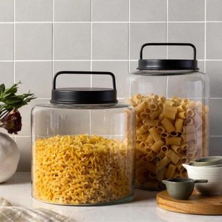 Two glass jars filled with pasta on a counter