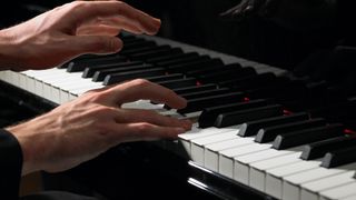 Close up of hands on a piano