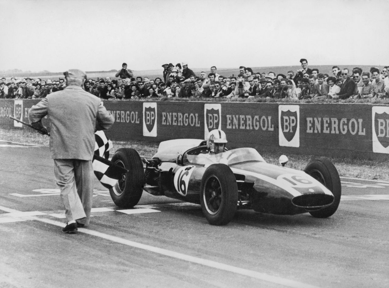 Australian racing driver Jack Brabham takes the chequered flag to win the French Grand Prix at Rheims in a Cooper-Climax T53, 3rd July 1960.(Photo by /Hulton Archive/Getty Images)