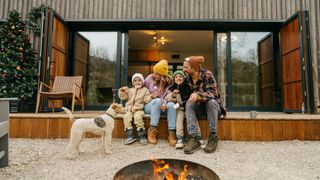 Family of four sitting outside with their dog