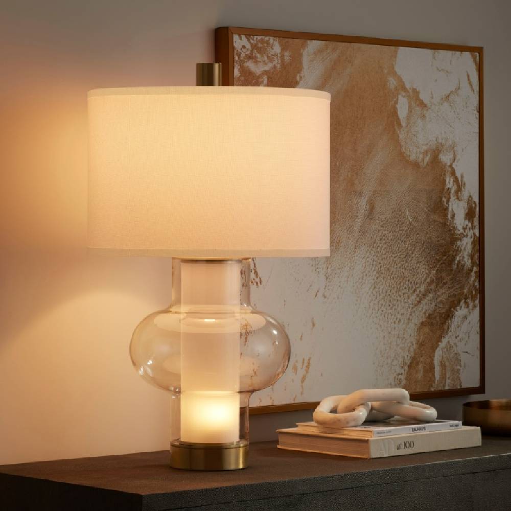 A modern, sleek entry table with a large glass side lamp with a cream shade from Lamps Plus.