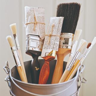 A bucket of paint brushes