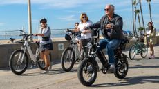 People ride their e-bikes along Hermosa Beach in California.