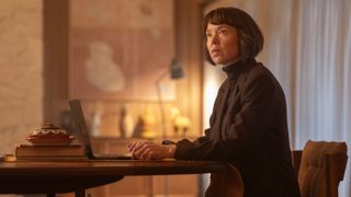 Anna Maxwell Martin in a dark top sits at a laptop as Lucy Betts-Taylor in Ludwig.