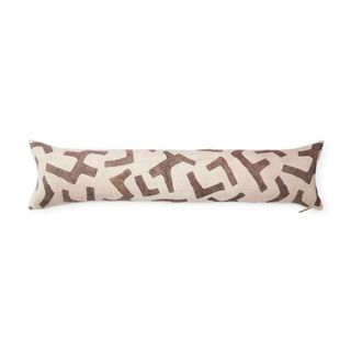 A long beige colored bolster cushion