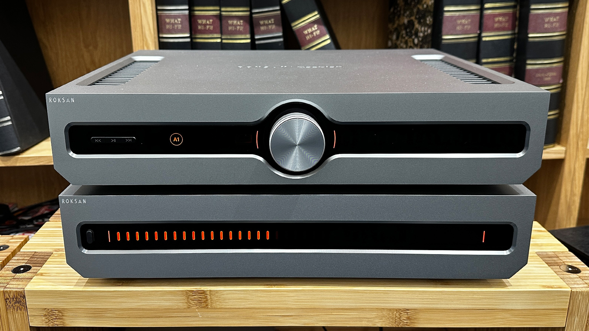 Roksan Caspian 4G Streaming Pre-Amplifier/Caspian 4G Power Amplifier on wooden hi-fi rack in front of bookcase