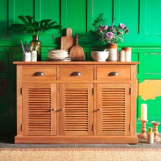 Hamilton Oak 3 Door Sideboard covered with potted plants and assorted plates and cutlery in a room with green panelled walls