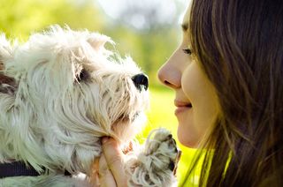 A woman nuzzles her dog.