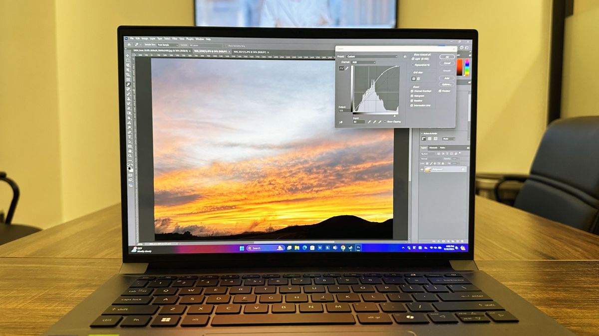 Acer Swift X 14 facing forward on a wooden table, with the display showing the Photoshop interface.