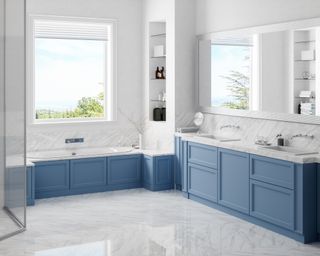 Clean bathroom with shaker style cornflower blue cupboards and gleaming white marble with gray veined floor, reflecting light from the window