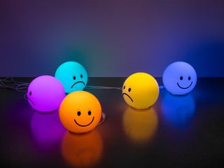 Smiling and frowning faces on colourful ball-shaped lamps