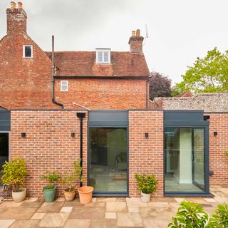 modern brick extension to listed building with large grey picture windows