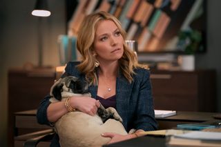 Becki Newton as Lorna Crane, craddling a dog in her arms, in episode 302 of The Lincoln Lawyer.