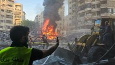 Lebanese emergency teams cordon off the perimeter of a fire at the site of Israeli strikes in Beirut