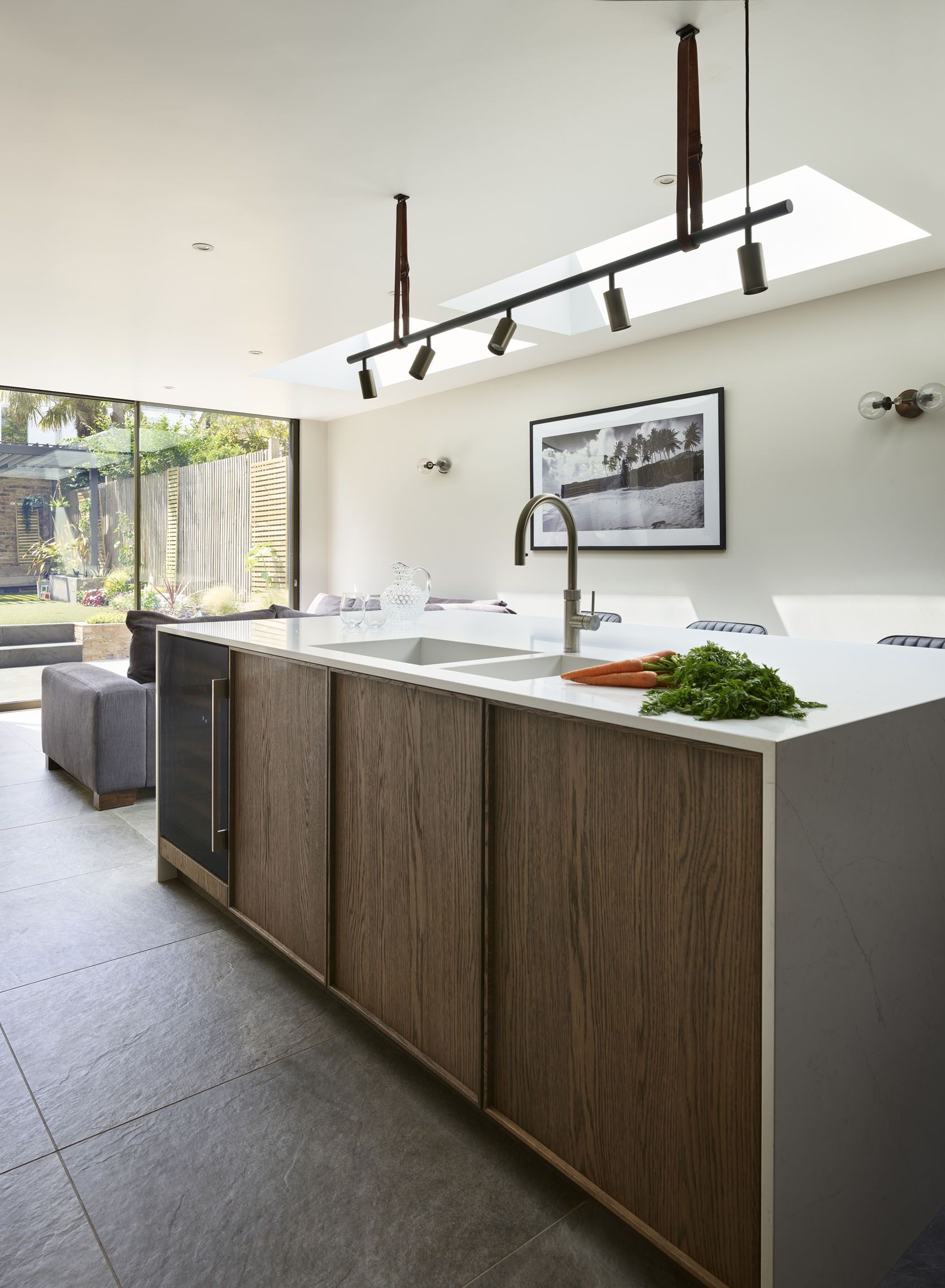 modern kitchen with lighting above the walnut style island, white countertops