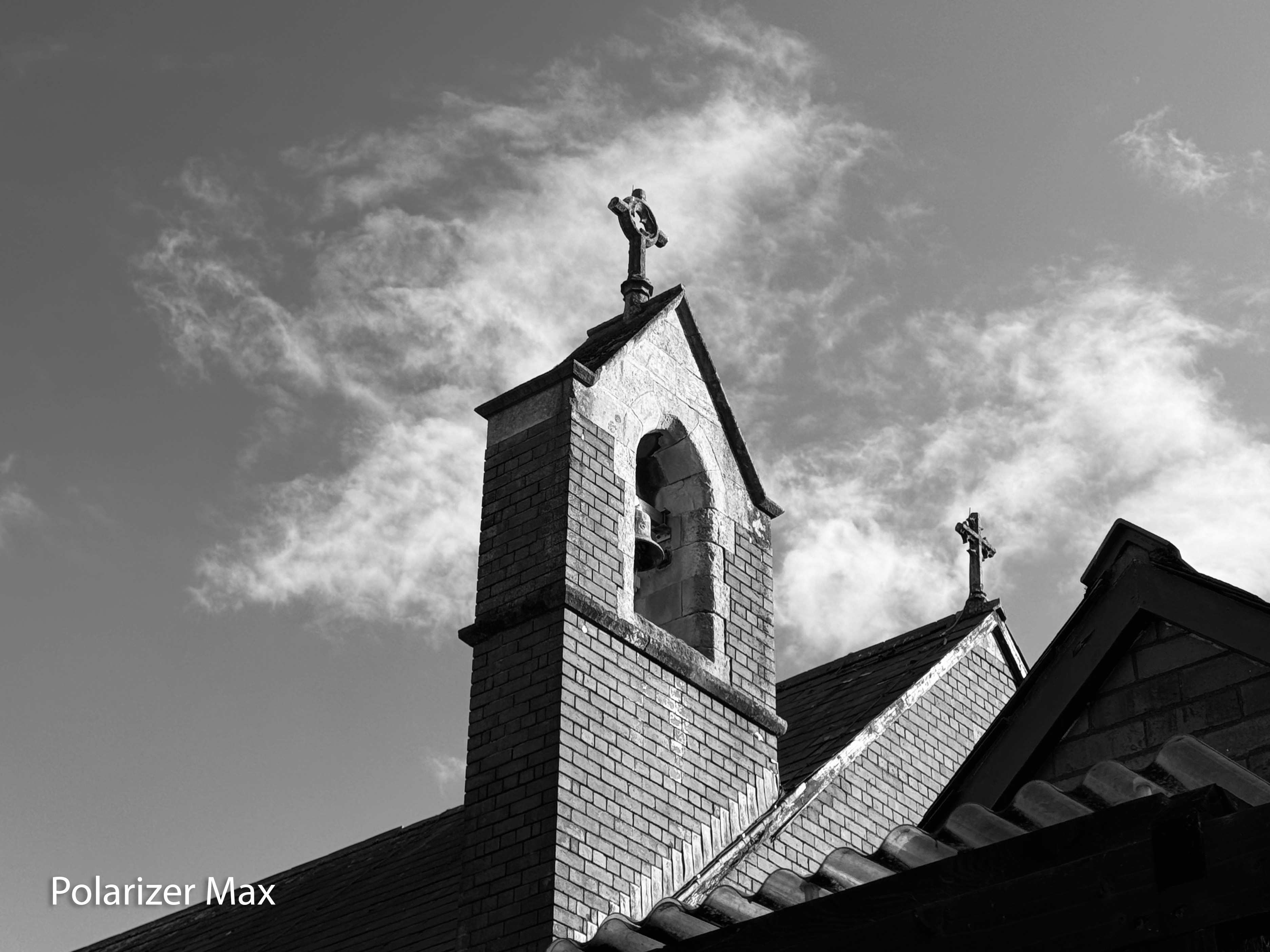 A monochrome photo of a church bell tower taken on an iPhone 15 Pro using the Sandmarc polarizing filter