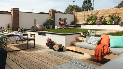 An outdoor space with decking, dining area with outdoor table, stairs, BBQ and decking decor