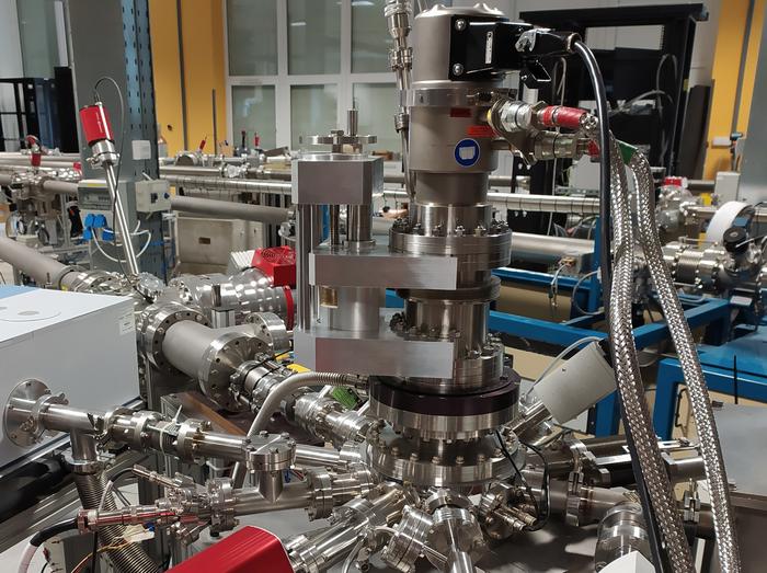 Photo of a metal machine with many silver metal pipes, valves and hoses.