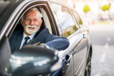 Senior businessman driving a car.