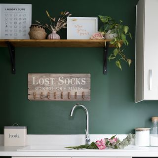 green utility room with reclaimed wood shelf sink chrome tap wooden sign