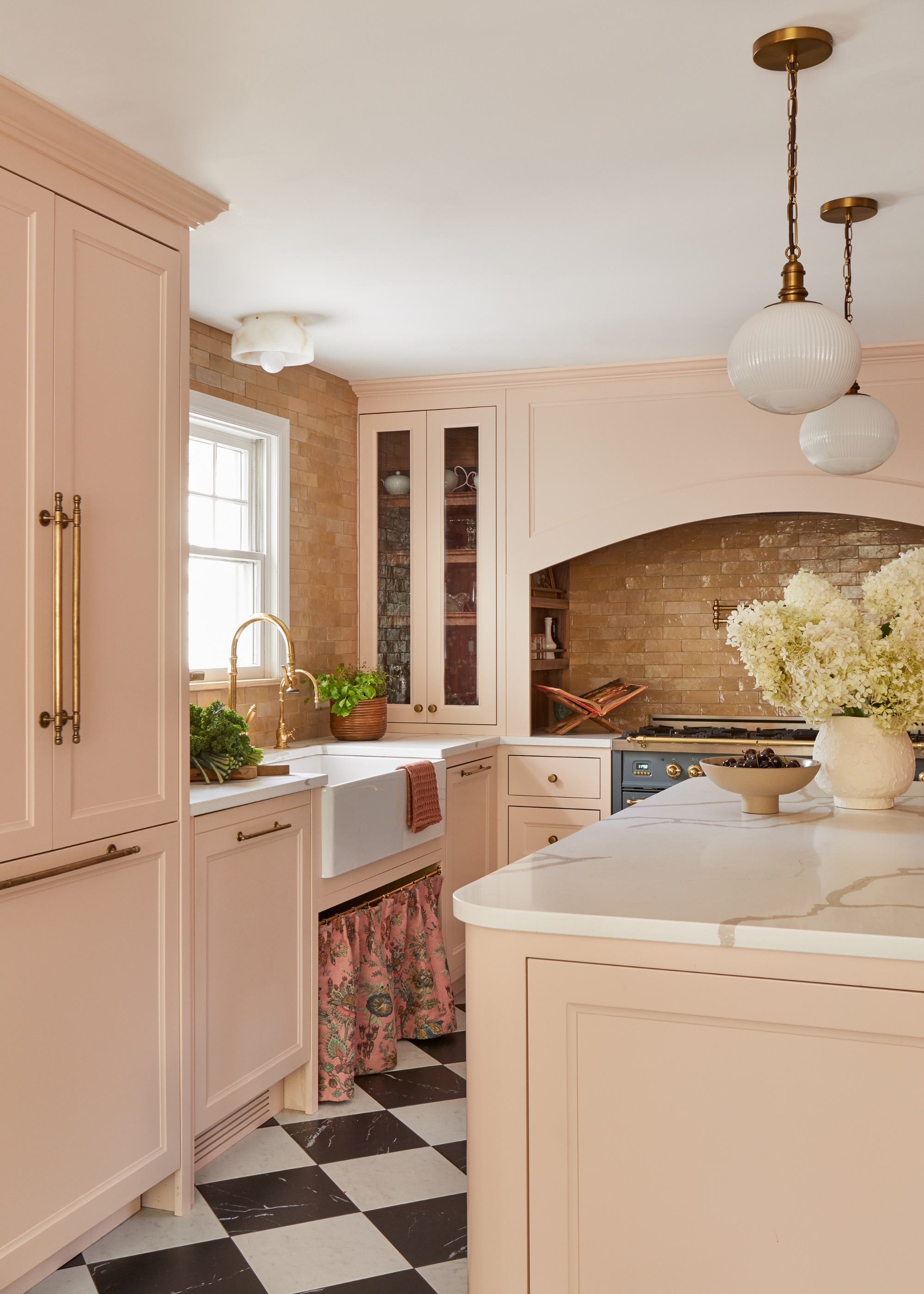 pale pink kitchen with checkerboard flooring and pendant lights