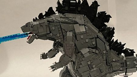 Lego Godzilla model seen from the side, breathing blue 'fire'